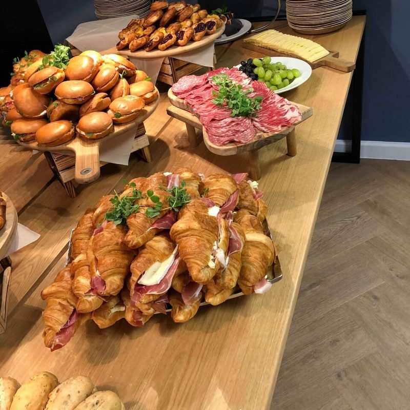 Corporate breakfast spread with croissants, rolls and cured meats