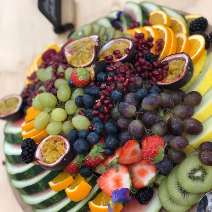 A fresh fruit platter with passion fruit and berries