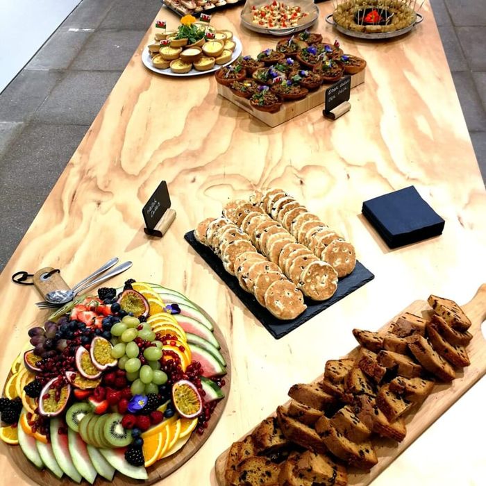 A long buffet table with fruit, biscuits and savouries